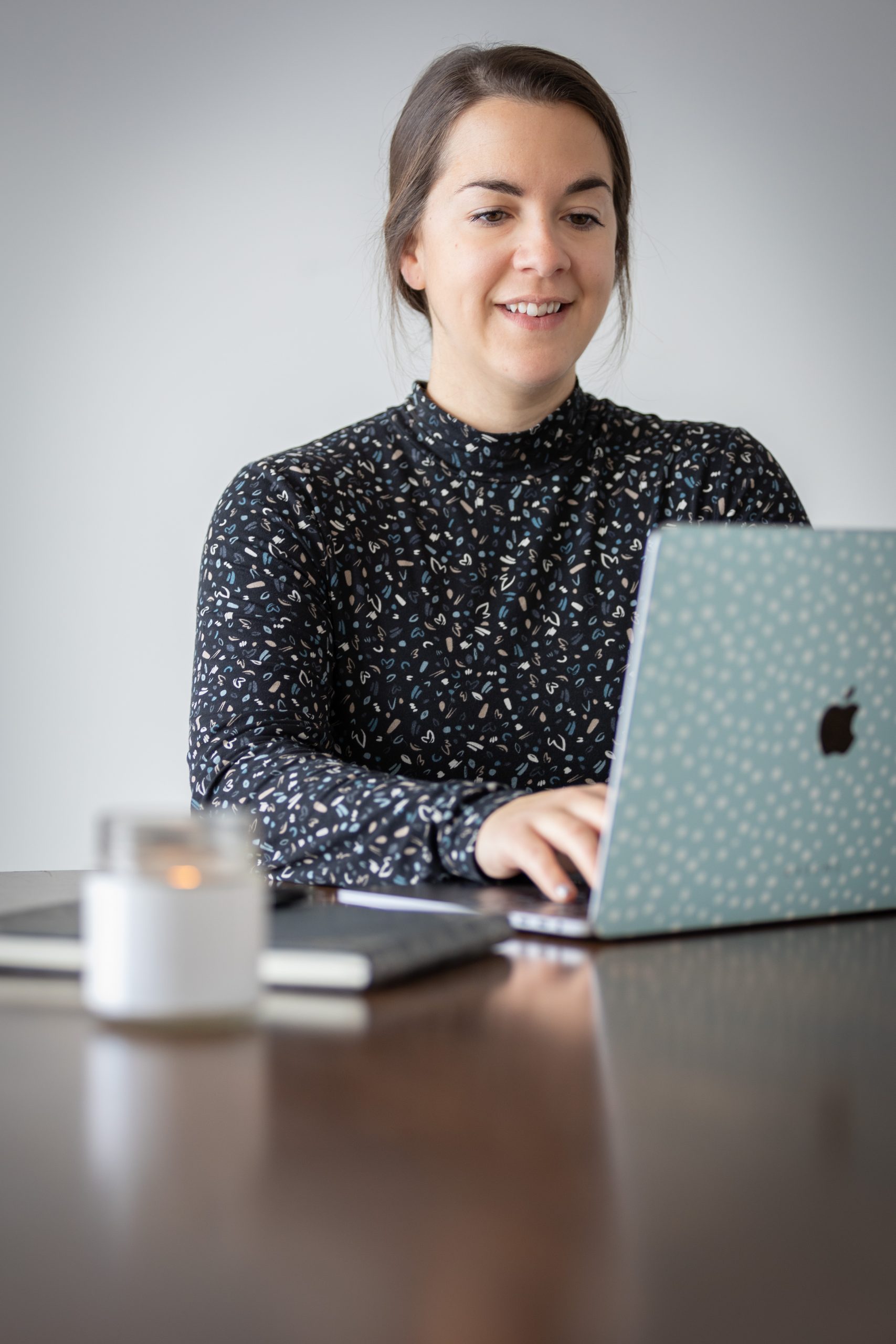 JoanieRobichaud-CreditGenevieveSmith Femme qui travaille à l'ordinateur et qui sourit pour la photo